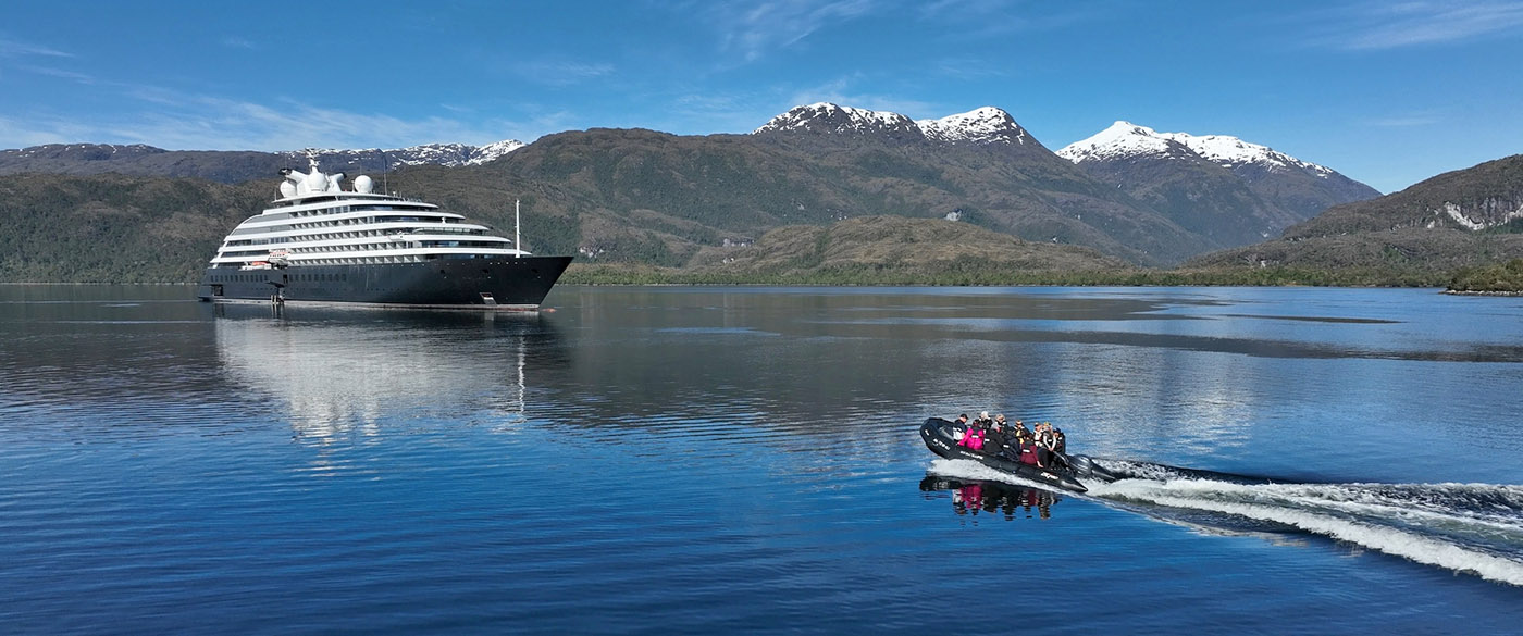 Icy blue waters of a fjord with mountains on the side